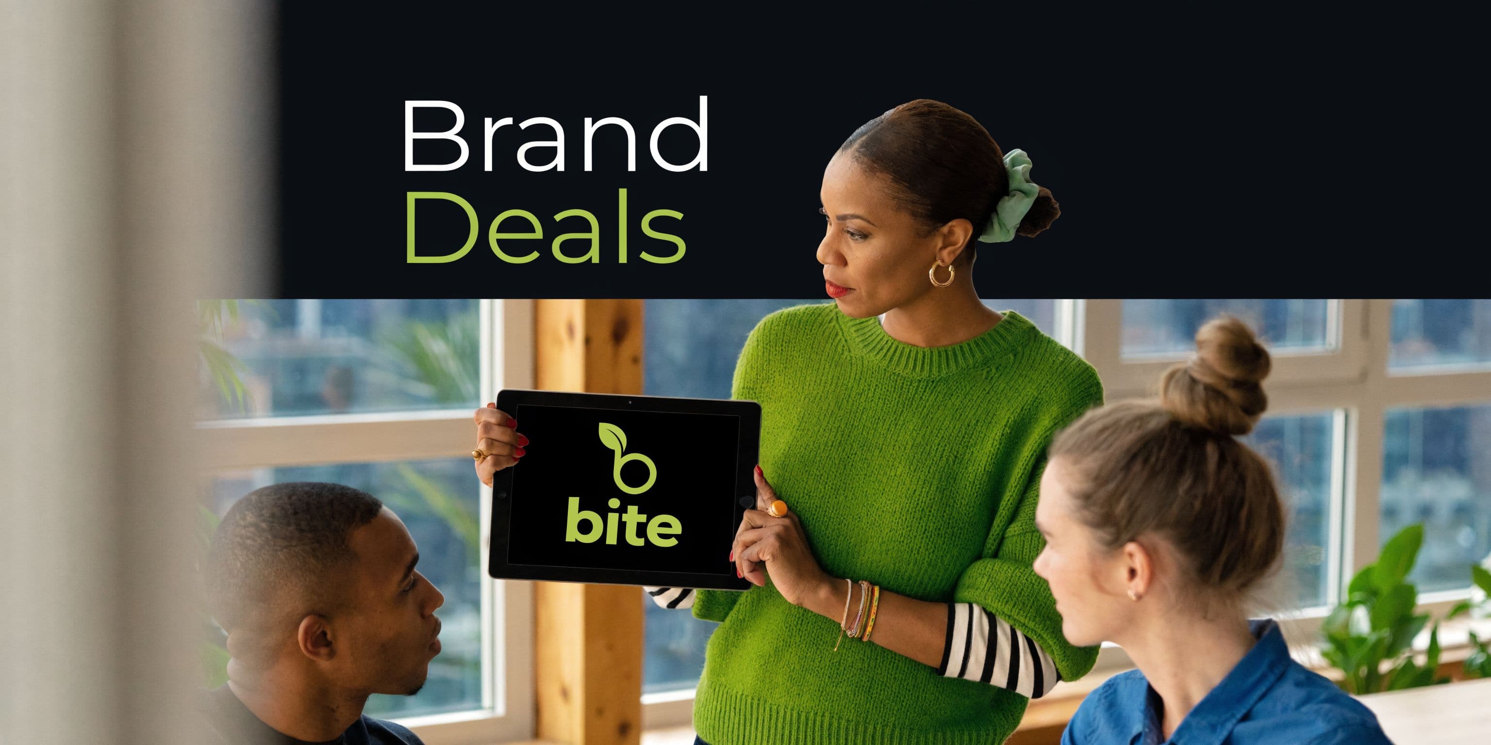 A woman in a green sweater holding a tablet displaying the bite logo for a brand deal presentation.