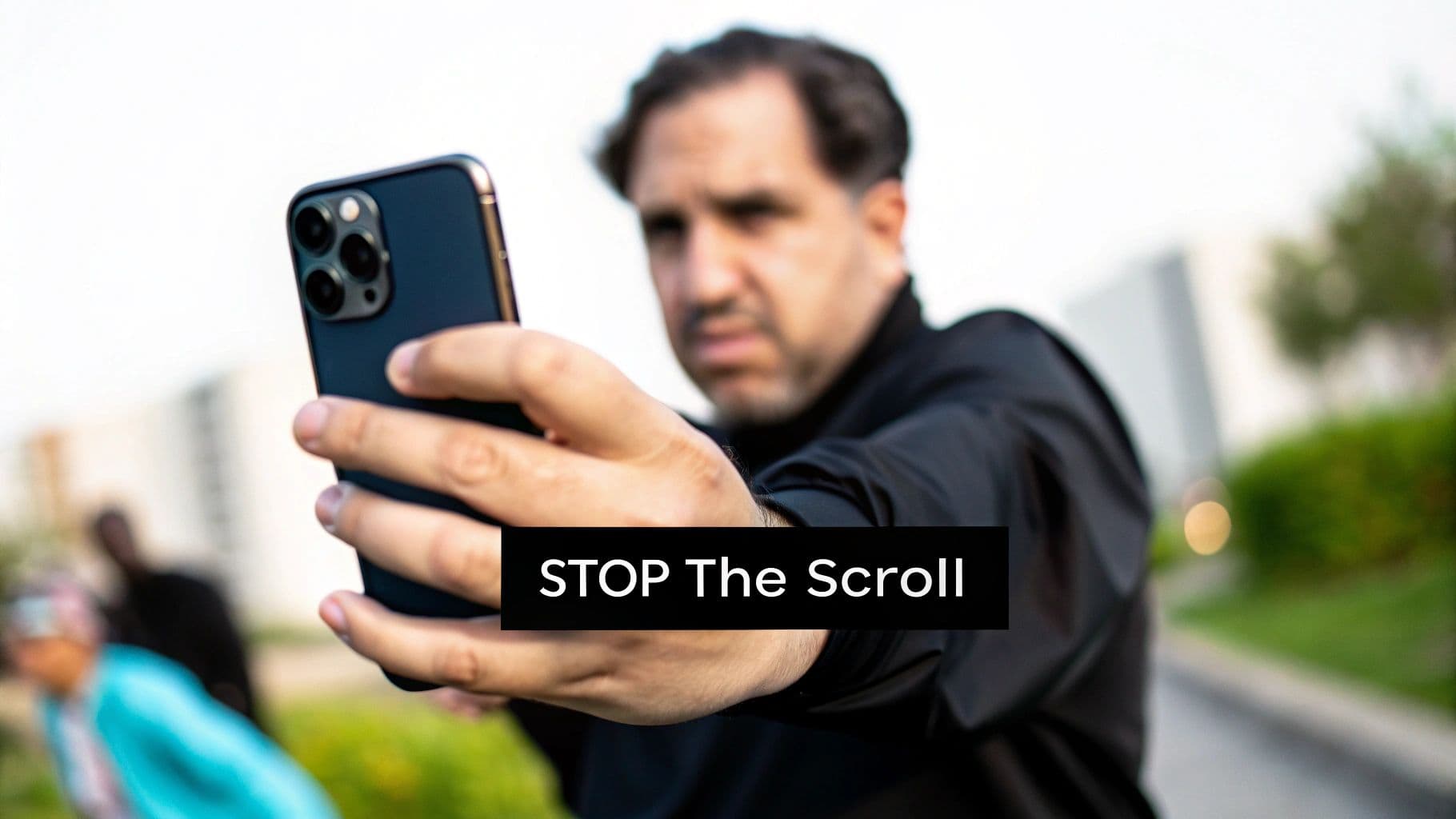 Un home aguanta un smartphone cap a l’espectador amb una samarreta negra, amb text superposat 'STOP The Scroll'.